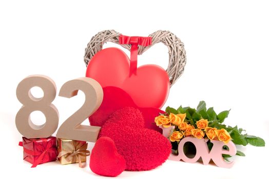 Number of age in a colorful studio setting with heart and gifts and yellow roses