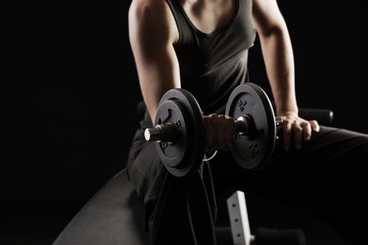 Young woman lifting the dumbbells