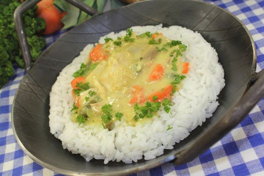 a pan with rice and colorful chicken fricassee