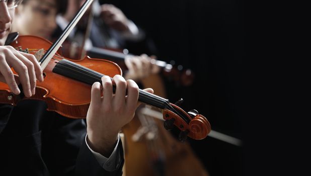 Symphony music, violinist at concert, hand close up