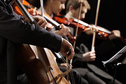 Symphony concert, a man playing the cello, hand close up