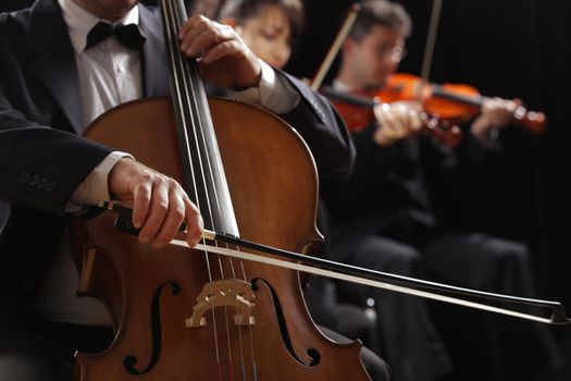 Symphony concert, a man playing the cello, hand close up