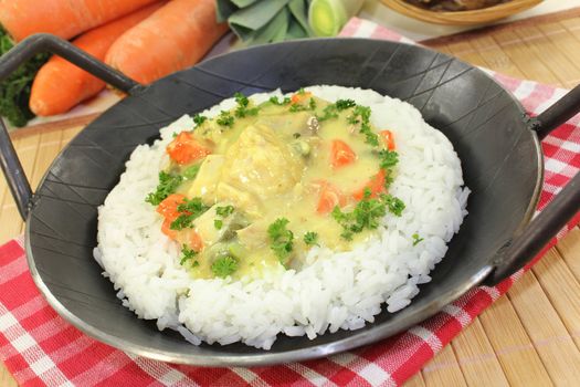 a pan with rice and colorful chicken fricassee