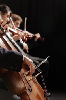 Symphony concert, a man playing the cello, hand close up