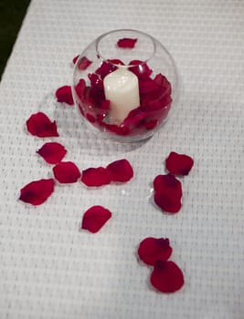 Ornamental candle with red rose petals