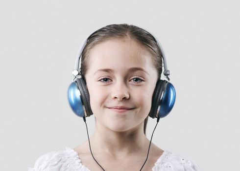 little pretty child listening music in headphones