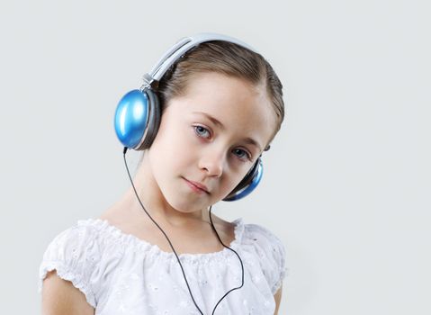little pretty child listening music in headphones