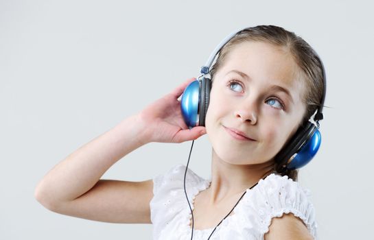 little pretty child listening music in headphones