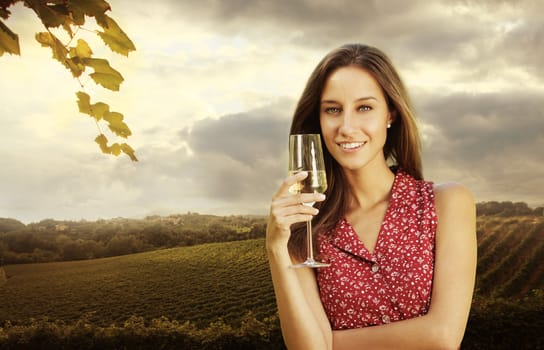 Beautiful woman in vineyard with a glass of champagne