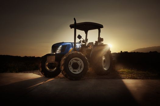 Tractor in the countryside at sunset