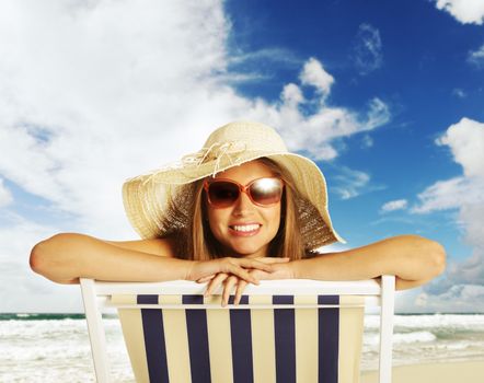 Beautiful young woman relaxing on beach chair