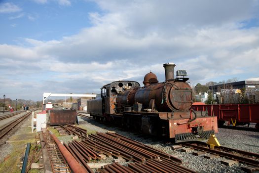 An old vintage reclaimed steam powered locomotive in a railway yard.
