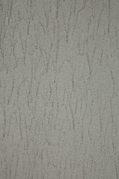 Wall with grey textured granular spray paint in excess with runs.