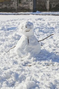 A little snowman with wooden branches for arms