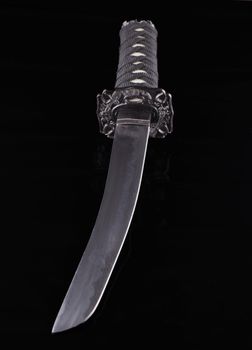 Close up of a katana over a black background