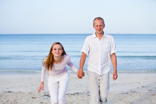 happy young couple in love having fun on the beach blue sky and sunshine 