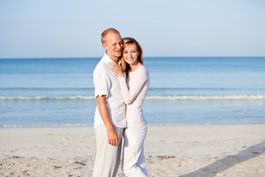 happy young couple in love having fun on the beach blue sky and sunshine 