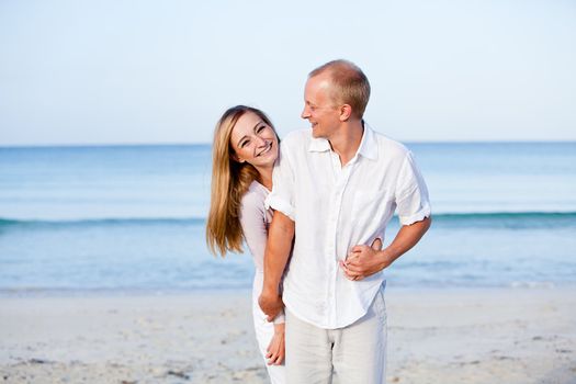 happy young couple in love having fun on the beach blue sky and sunshine 