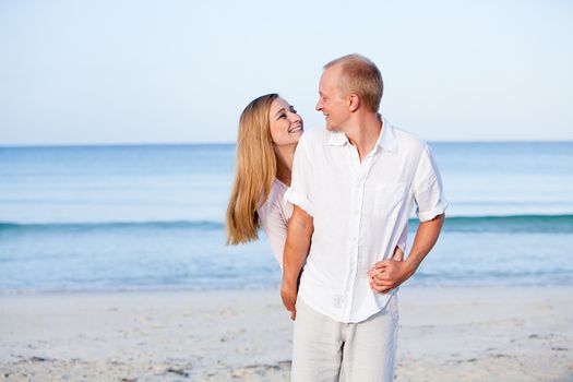 happy young couple in love having fun on the beach blue sky and sunshine 