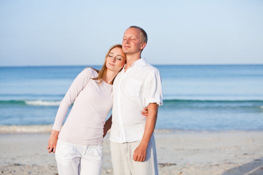 happy young couple in love having fun on the beach blue sky and sunshine 