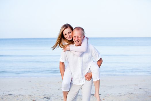 happy young couple in love having fun on the beach blue sky and sunshine 