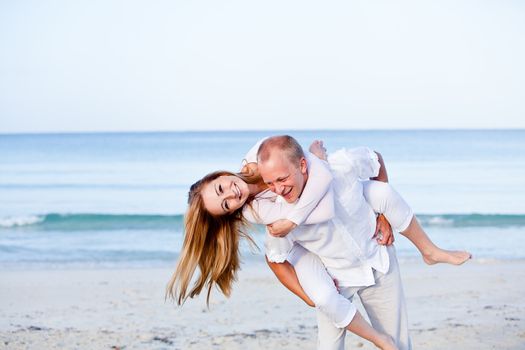 happy young couple in love having fun on the beach blue sky and sunshine 