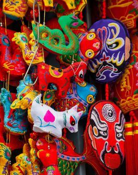 Chinese Colorful Souvenir Silk Decorations Beijing, China.  These decorations are traditional Chinese symbols, including masks from Sichuan.