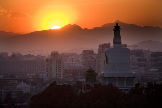 Beihai Stupa with Sunset and Mountains in Background, taken from Jinshang Park, Beijing, China