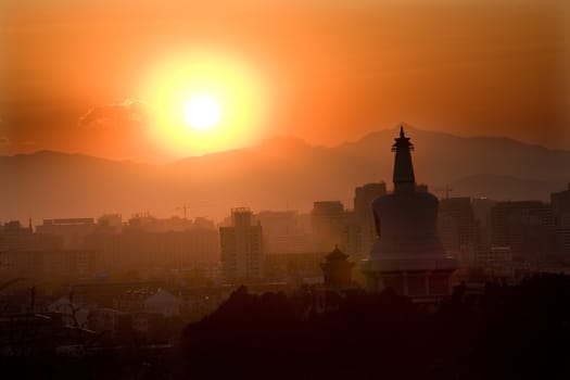 Beihai Stupa with Sunset and Mountains in Background, taken from Jinshang Park, Beijing, China