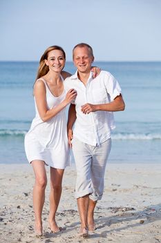 happy young couple in love having fun on the beach blue sky and sunshine 