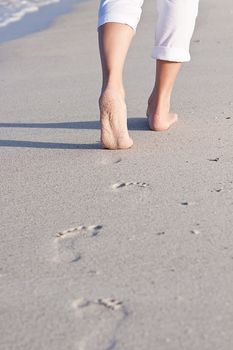 walking barefoot in the sand in summer holidays on beach