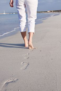 walking barefoot in the sand in summer holidays on beach