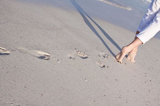 walking barefoot in the sand in summer holidays on beach