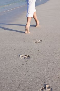 walking barefoot in the sand in summer holidays on beach