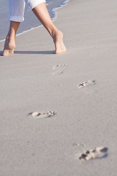 walking barefoot in the sand in summer holidays on beach