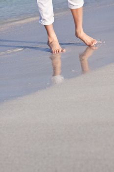 walking barefoot in the sand in summer holidays on beach