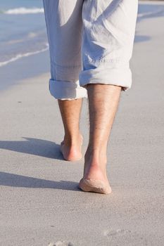 walking barefoot in the sand in summer holidays on beach