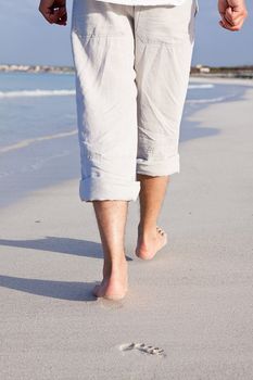 walking barefoot in the sand in summer holidays on beach