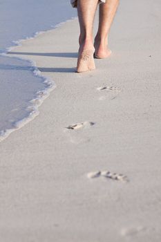 walking barefoot in the sand in summer holidays on beach
