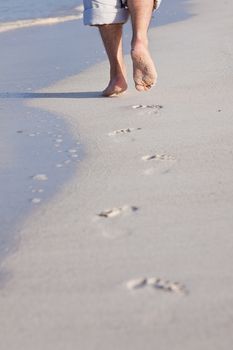 walking barefoot in the sand in summer holidays on beach