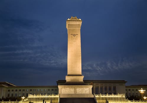 Monument To The People's Heroes of the Revolution Great Hall of the People Background Tiananmen Square Beijing China  Erected in 1958.  The calligraphy, writing, on the monument is by Mao Tse Tung.