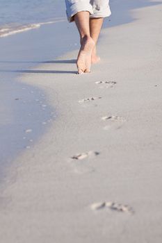 walking barefoot in the sand in summer holidays on beach