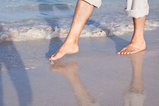 walking barefoot in the sand in summer holidays on beach