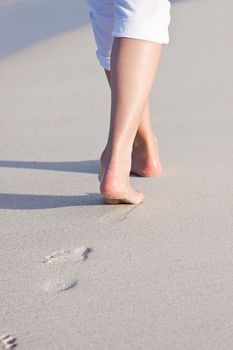 walking barefoot in the sand in summer holidays on beach