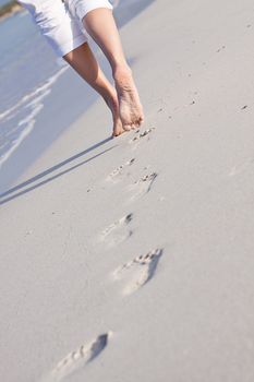 walking barefoot in the sand in summer holidays on beach
