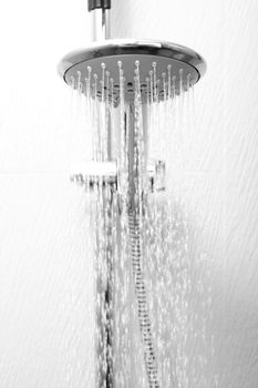 A hotel shower head flowing with water