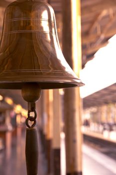 old bell in train station with sunrise light