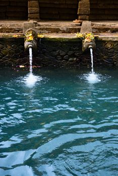 Fountains and pool with holy spring water in Tirta Empul temple, Bali, Indonesia 