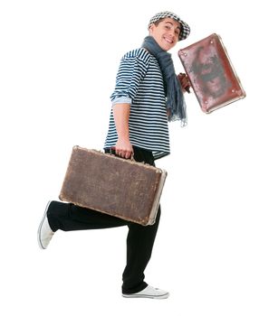 Happy running young male traveller with two old vintage suitcases isolated on white background