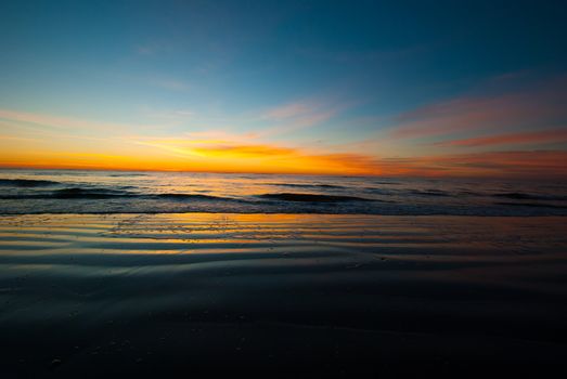 Photogrpah of a sunrise before the sun crests the horizon of a Saint Simons Island Beach.